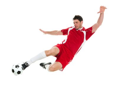 Full length / one man only / side view / profile view of 30-39 years old handsome people caucasian male / mid adult men / mid adult soccer player kicking / mid-air in front of white background wearing soccer uniform who is serious / confidence / concentration and holding soccer ball / ball / sport / soccer field