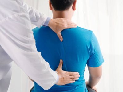 Doctor physiotherapist doing healing treatment on man's back.Back pain patient, treatment, medical doctor, massage therapist.office syndrome