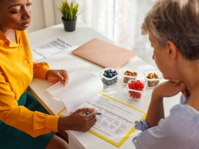 Female nutritionist discussing with her client about fruit portion in diet.